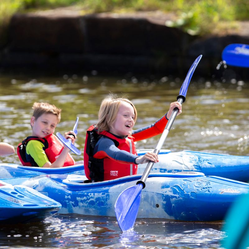 a group of people riding on the back of a boat in the water