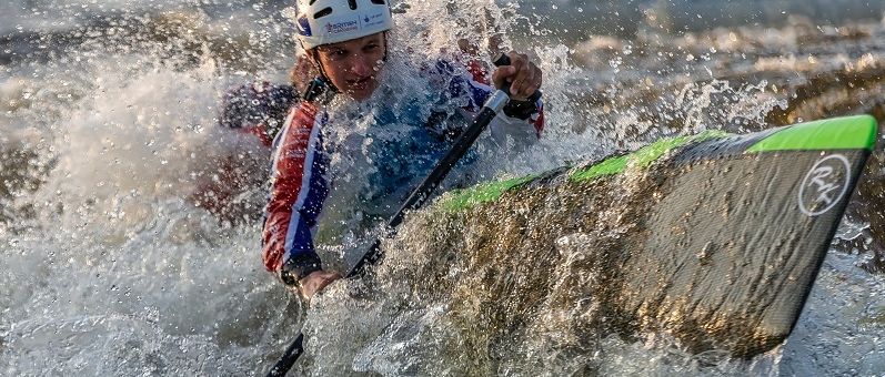 a young boy riding a wave on top of a body of water