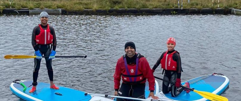 sup_810_340_80_c1 a group of people rowing a boat in the water