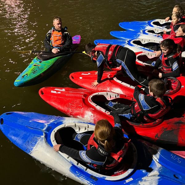 a group of people riding on the back of a boat in the water