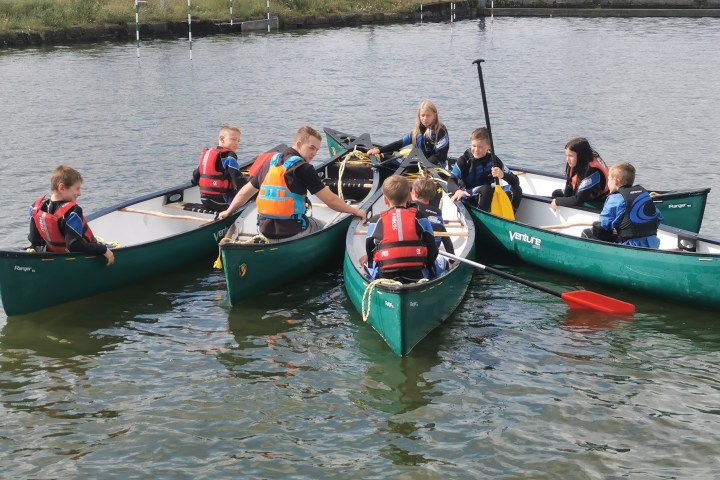 a group of people riding on the back of a boat in the water
