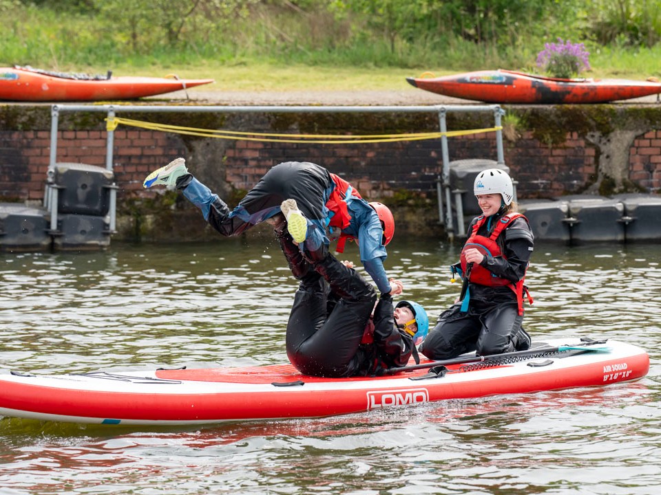 a group of people in a small boat in a body of water