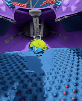 Interior of a colorful kayak with textured purple and blue seating.