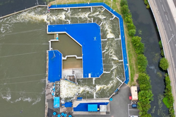 Aerial view of a blue artificial water course next to a road.