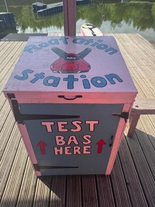 Box labeled 'Flotation Station' and 'Test BAs Here' on a wooden deck.